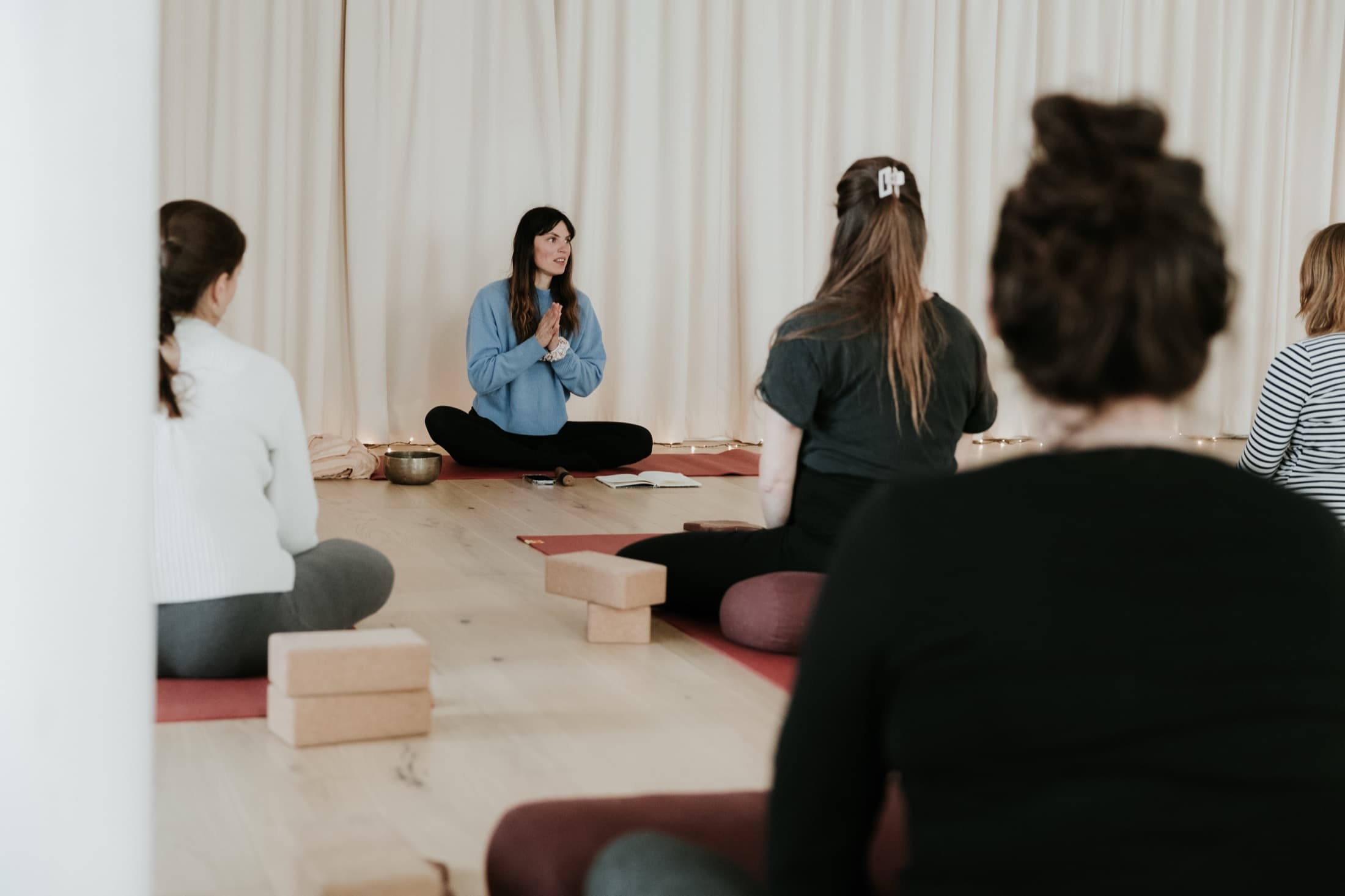 Femmes enceintes assises en cercle sur leurs tapis pendant un cours de yoga prénatal à Bordeaux